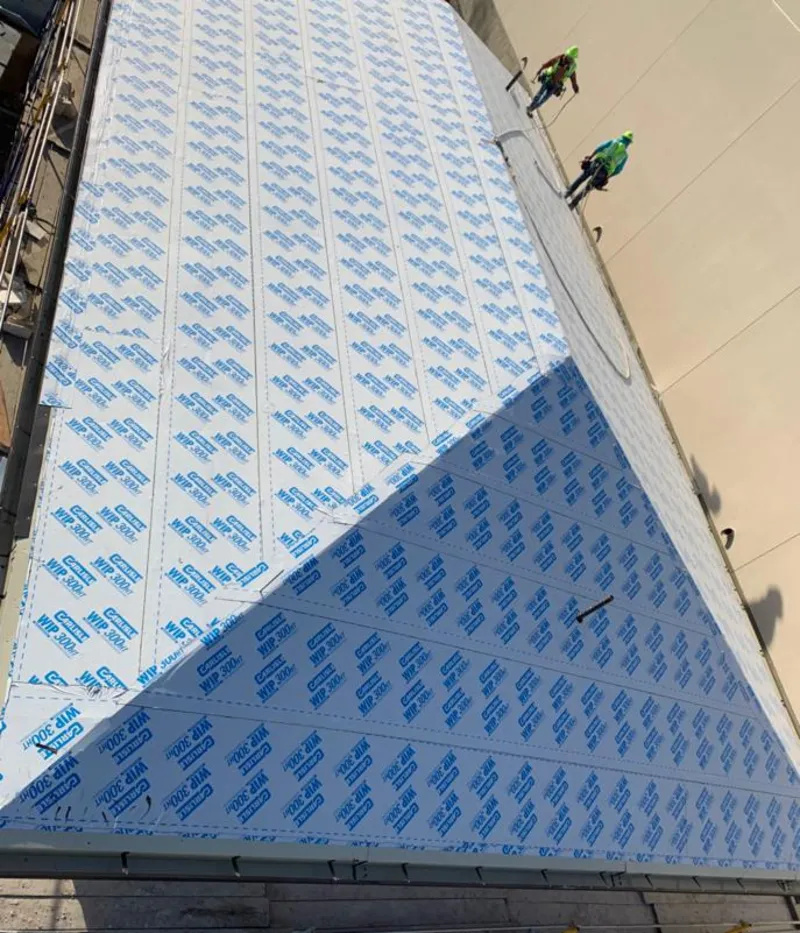 Professional roofers installing underlayment on a metal roof in Hyde Park